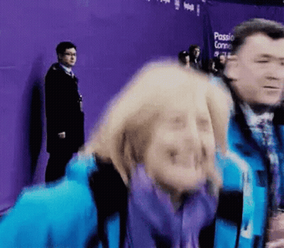 Woman In Blue Jacket Making Funny Face, Man Behind GIF