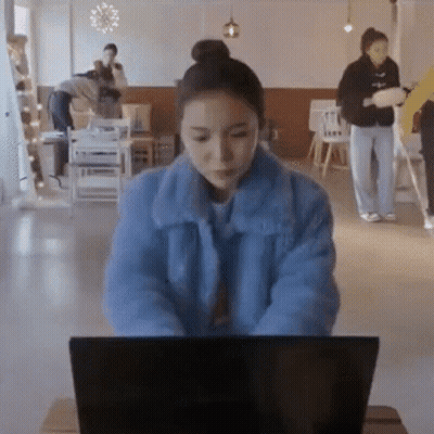 Woman In Blue Jacket Typing On Laptop GIF