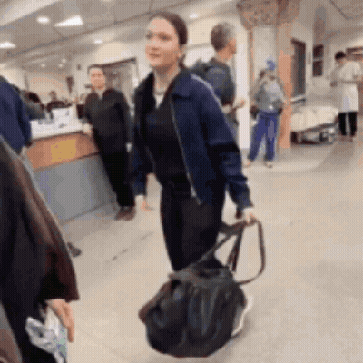 Woman In Blue Jacket Walking With Black Bag GIF