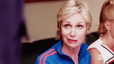 Woman In Blue Jacket With Red Stripes Sitting In Front Of Fox Sign GIF