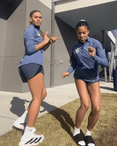 Woman In Blue Jacket With UCSD Logo Next To Woman In Shorts GIF