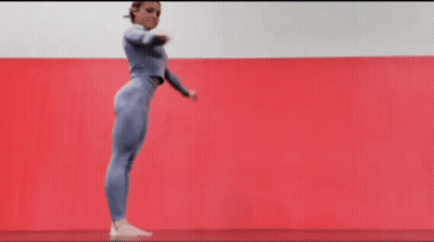 Woman In Blue Jumpsuit Doing Yoga Pose On Red Mat GIF
