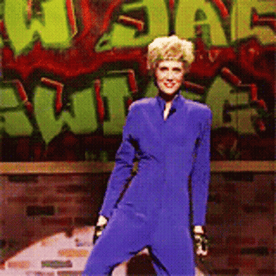 Woman In Blue Jumpsuit With Graffiti Saying What GIF