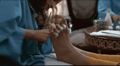 Woman in Blue Robe Giving Pedicure