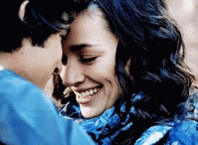 Woman In Blue Scarf Smiling As Man Kisses Forehead GIF