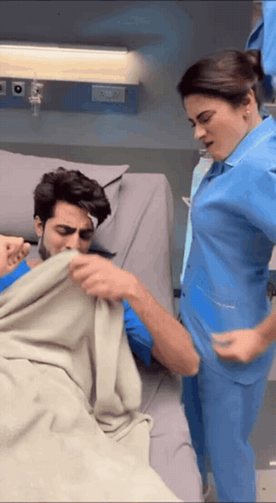 Woman In Blue Scrub And Man In Hospital Bed GIF
