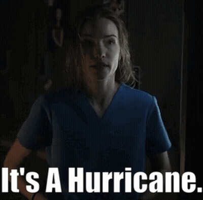 Woman In Blue Scrub Top Saying It's A Hurricane GIF