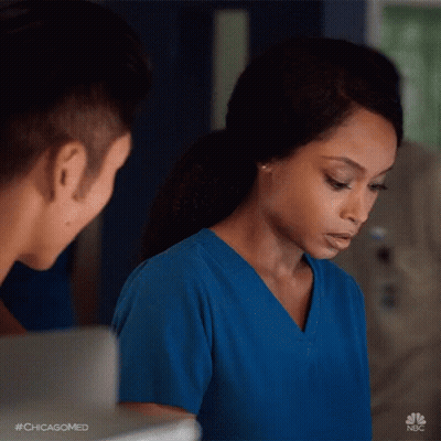 Woman In Blue Scrubs Looking At Man GIF