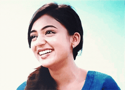 Woman in Blue Shirt and Earrings Smiling