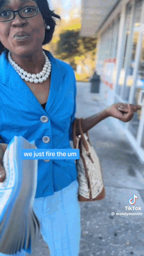 Woman In Blue Shirt And Pearls Holding Book GIF