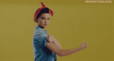 Woman In Blue Shirt And Red Bandana Flexing Muscles GIF