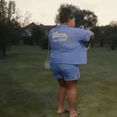 Woman In Blue Shirt And Shorts In Grassy Field GIF