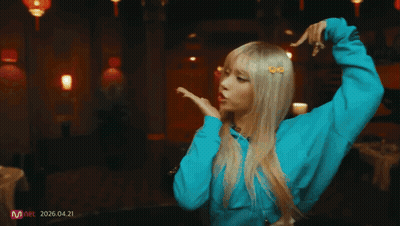 Woman In Blue Shirt Dancing In Front Of Red Wall With Lanterns GIF