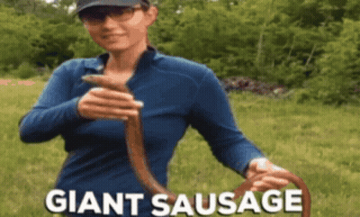 Woman In Blue Shirt Holding Giant Sausage GIF