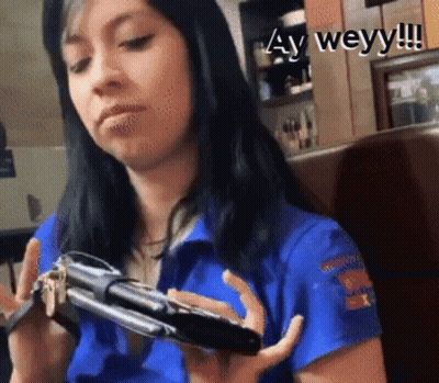 Woman In Blue Shirt Holding Phone And Keys GIF