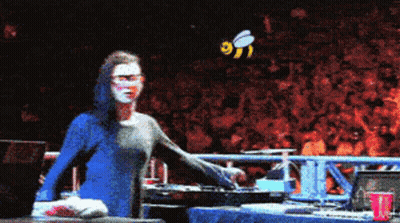 Woman In Blue Shirt In Front Of Crowd With Bee GIF