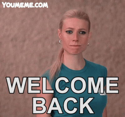 Woman In Blue Shirt In Front Of Welcome Back Sign GIF