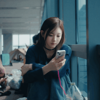 Woman In Blue Shirt Looking At Cell Phone GIF