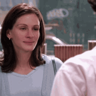 Woman In Blue Shirt Looking At Man In Pink GIF