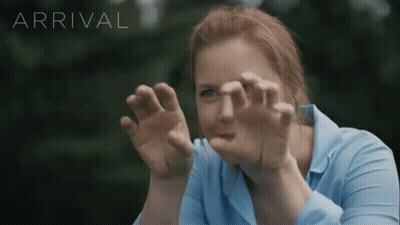 Woman In Blue Shirt Looking Through Glass Arrival GIF