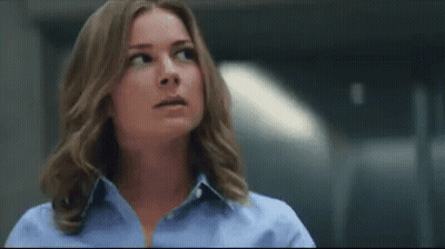 Woman In Blue Shirt Looking Up In Dark Room GIF