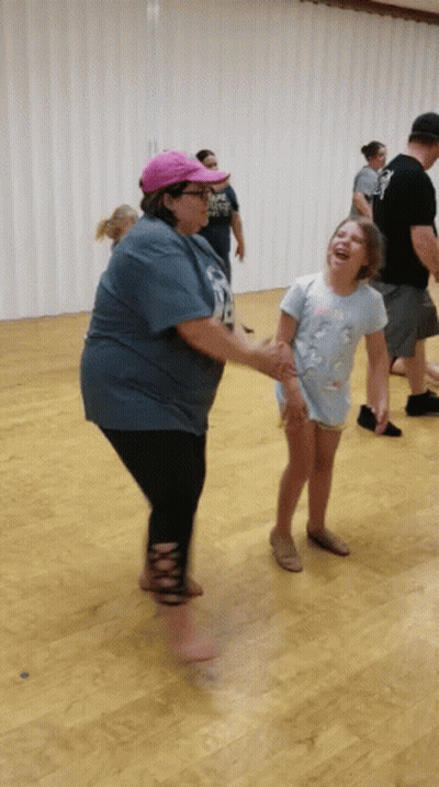 Woman In Blue Shirt Number 18 Holding Hands With Little Girl GIF