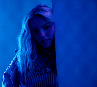 Woman In Blue Shirt Peeking From Behind Blue Wall GIF