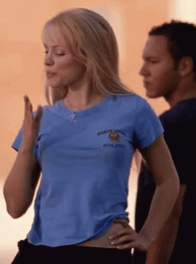 Woman in Blue Shirt Saying Athletics Next to Man