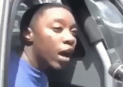 Woman In Blue Shirt Sitting In Car With Mouth Open GIF