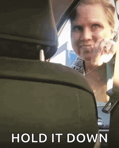 Woman In Blue Shirt Sitting In Car With Mouth Open GIF