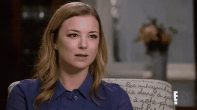 Woman In Blue Shirt Sitting In Chair With Letter E GIF