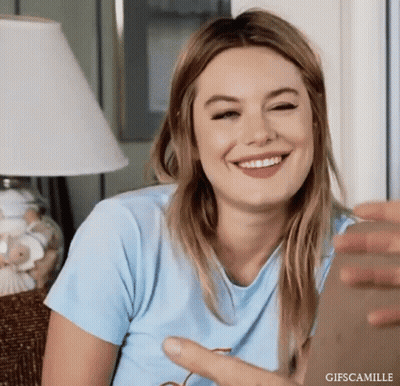 Woman In Blue Shirt Sitting On Couch Smiling GIF