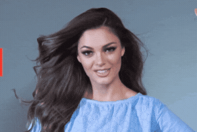 Woman In Blue Shirt Smiling With Hair Blowing GIF