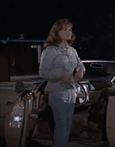 Woman In Blue Shirt Standing Next To Car At Night GIF
