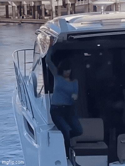 Woman in Blue Shirt With Arms Up on Boat