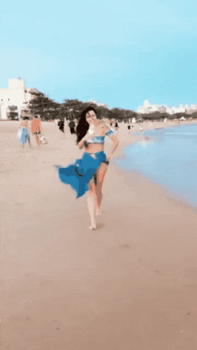 Woman In Blue Skirt Running Into Ocean GIF