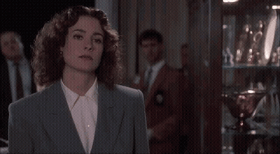 Woman In Blue Suit Standing In Front Of Trophy Case GIF