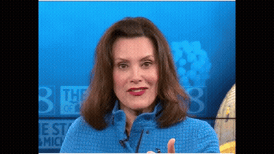 Woman In Blue Sweater In Front Of Sign Saying The 3 Best Of Michigan GIF