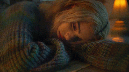 Woman In Blue Sweater Laying On Stomach GIF