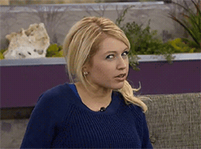 Woman In Blue Sweater Looking At Camera GIF