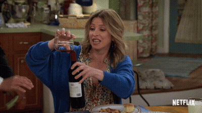 Woman In Blue Sweater Pouring Wine GIF
