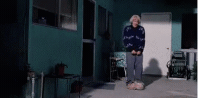Woman In Blue Sweater Standing In Front Of Building GIF