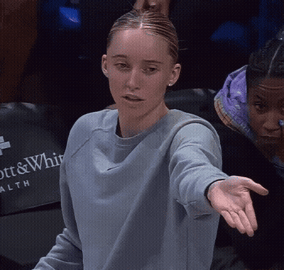 Woman In Blue Sweatshirt Sitting In Front Of Ott & Whitaker Health Sign GIF
