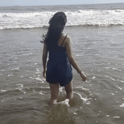 Woman In Blue Swimsuit Standing In Ocean GIF