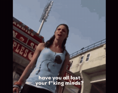 Woman In Blue Tank Top In Front Of Plesco Sign GIF