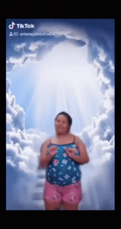 Woman In Blue Top And Pink Shorts Under Cloudy Sky GIF