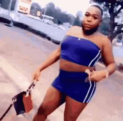 Woman In Blue Top And Shorts On Sidewalk GIF