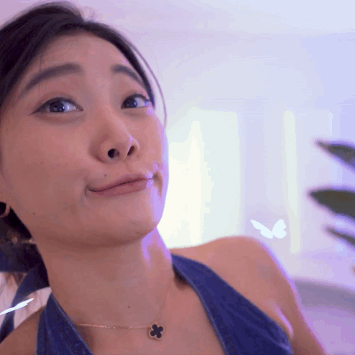 Woman In Blue Top With Flower Necklace GIF