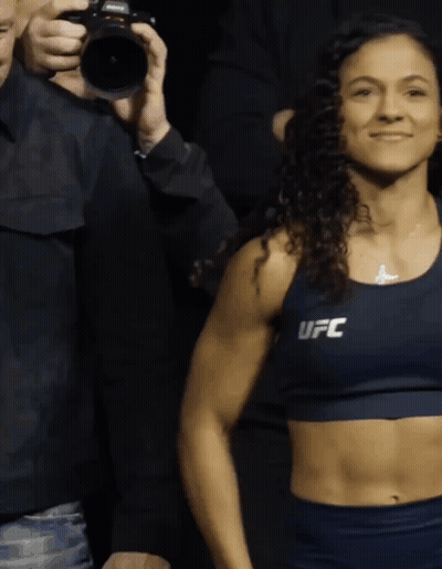 Woman In Blue UFC Top In Front Of Man Holding Camera GIF