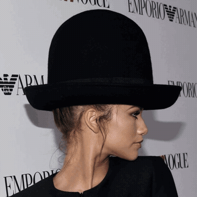 Woman In Bowler Hat In Front Of Emporio Armani Sign GIF